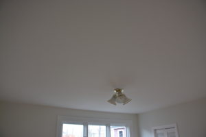 (After) Stucco removed, ceiling skimmed smooth with plaster and painted.